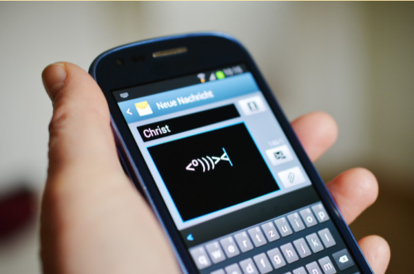 Imagem de um celular com a tela em uma mensagem de sms.