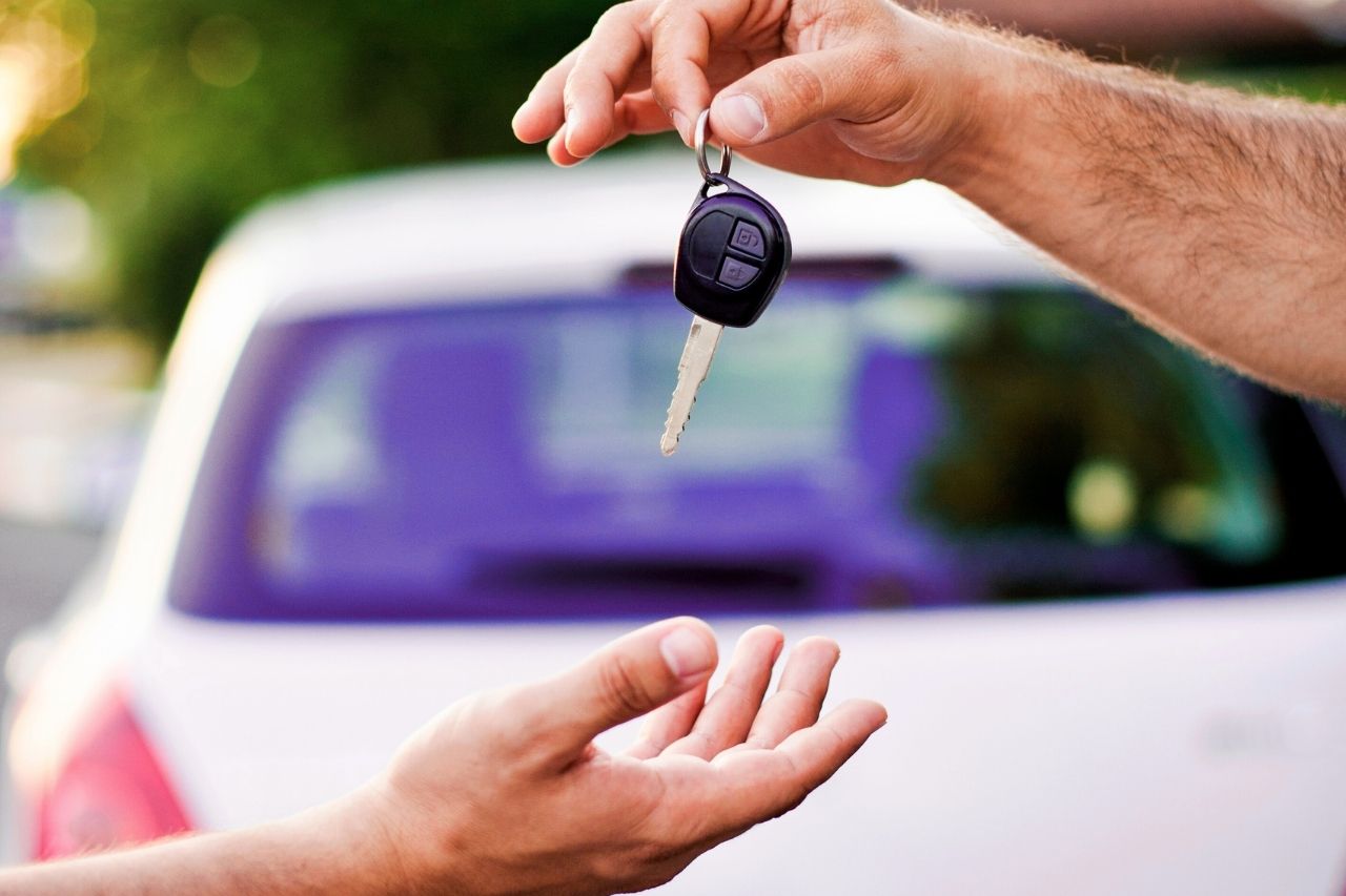 Pessoa recebendo a chave de um carro após escolher consórcio para comprar veículo de forma planejada