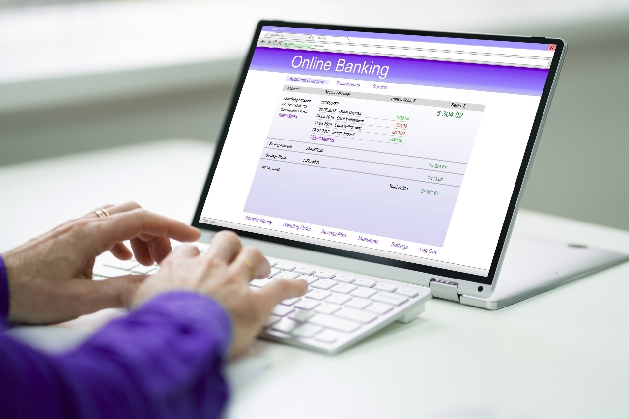 Empréstimo com garantia veicular para autônomos: como comprovar renda - Juros Baixos Pessoa acessando extrato bancário online no notebook para organizar comprovantes de renda usados na análise de empréstimo com garantia veicular